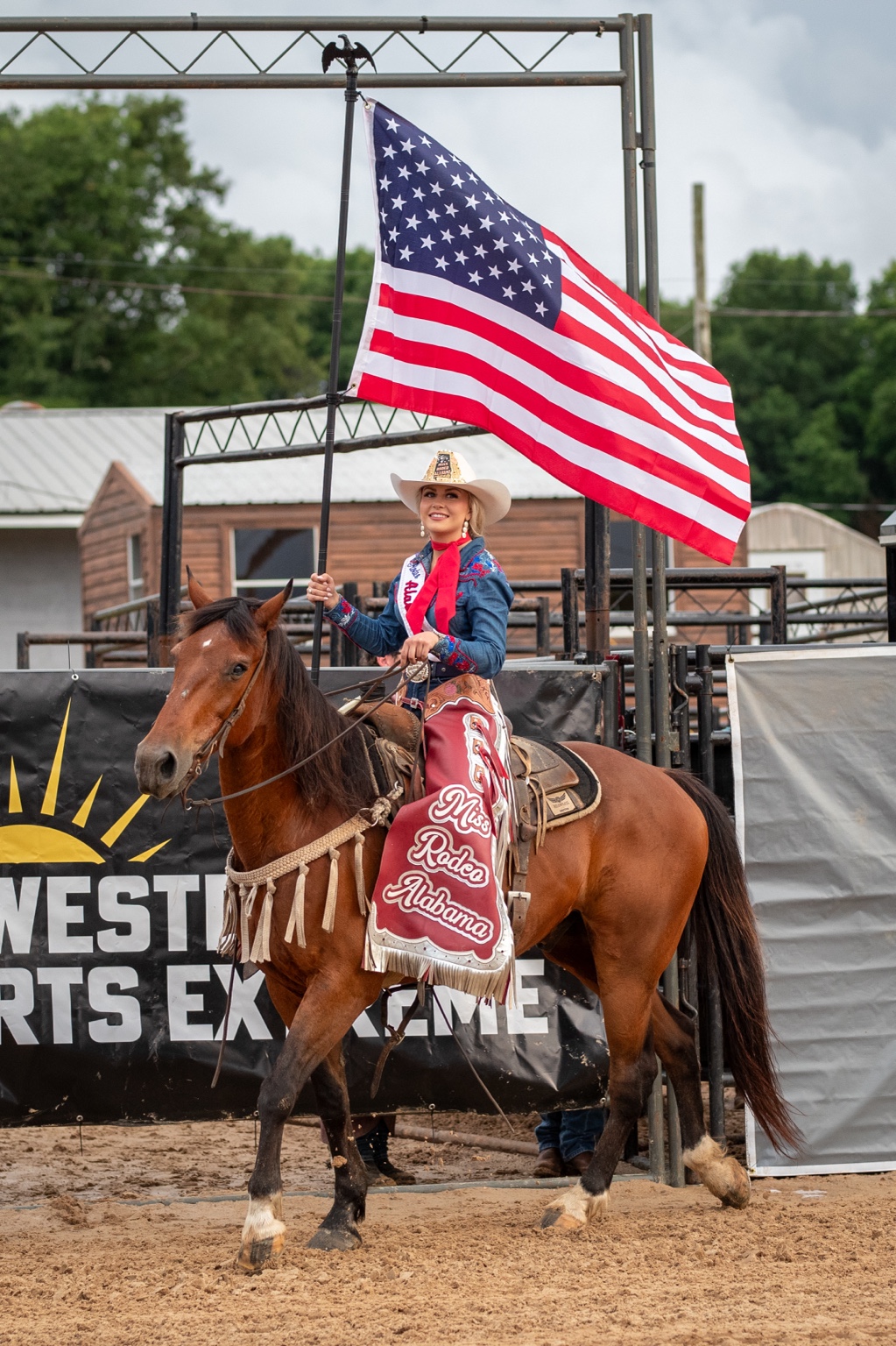 Flag bearer on horseback carrying the American flag at a Western Sports Extreme event